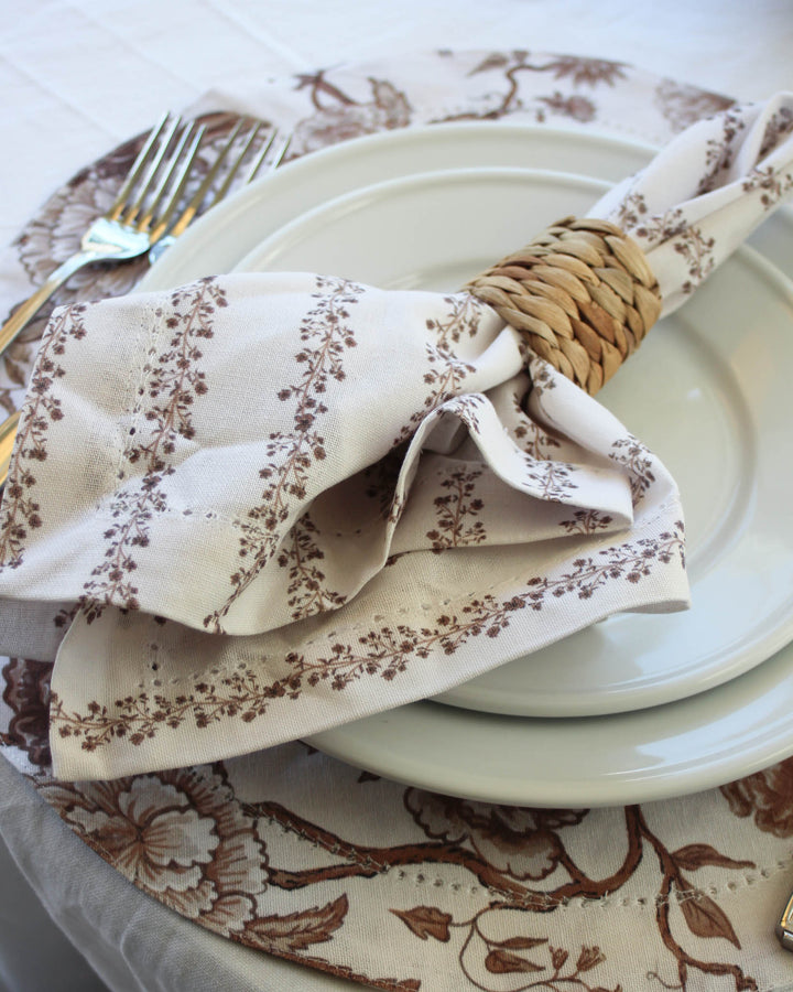 Decorative table setting with floral-patterned napkin and placemat.