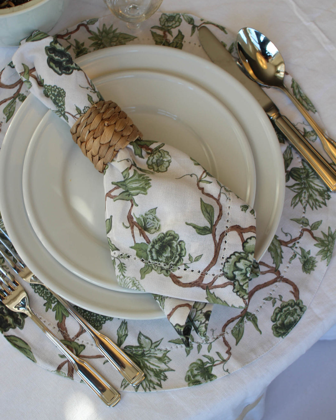 Florence collection round placemats in 100% cotton with hand-drawn green floral print for polished table settings.
