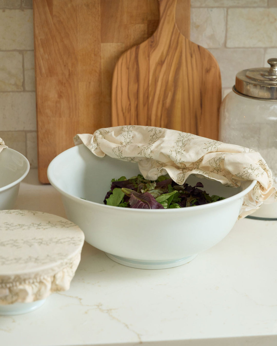 Cream floral stripe cotton bowl covers in three reusable sizes with soft elastic edges and decorative ruffle details, designed for covering dough, storing food, preparing dishes ahead, protecting serving bowls, holiday baking, hostess gifts, housewarming gifts, and year-round kitchen use.