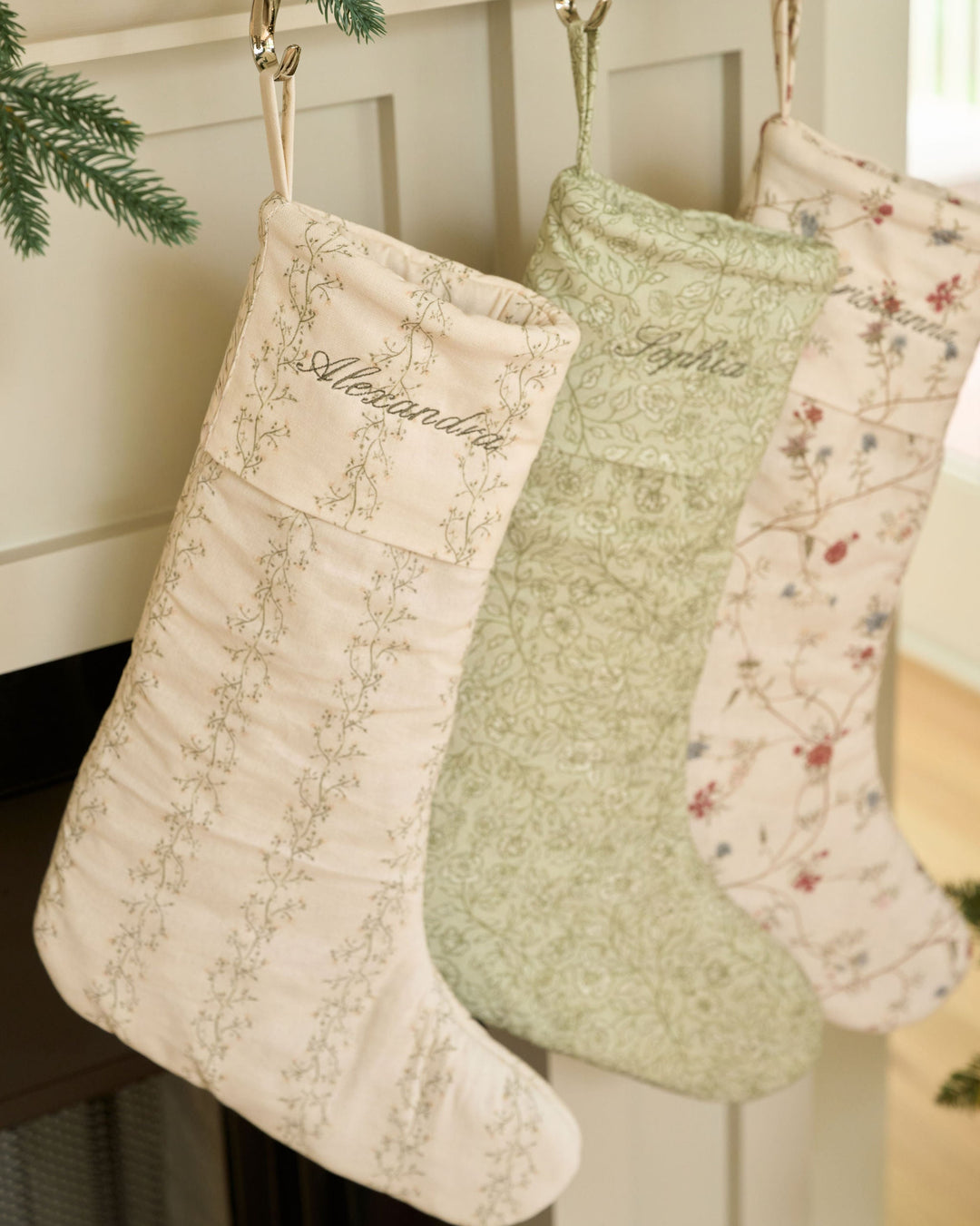Meadow floral stripe Christmas stocking in cream, moss green, and pale yellow with personalized monogram embroidery and classic holiday mantel decor.