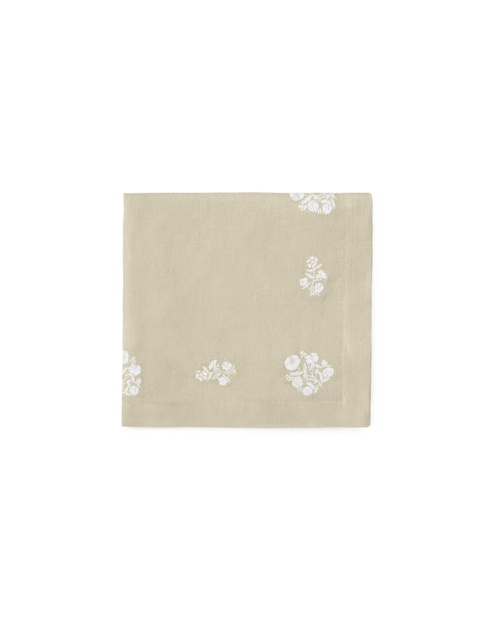 Showcasing a natural beige linen-cotton blend, these embroidered napkins are a staple for country-style hosting. This set of 4 features white floral motifs that pop against the neutral fabric. Styled here with a woven rope napkin ring and white scalloped plates, they offer a tactile, layered look for an Easter garden party. These 20x20 napkins are durable yet elegant, making them an ideal housewarming gift for someone who loves a clean, botanical-inspired spring aesthetic.