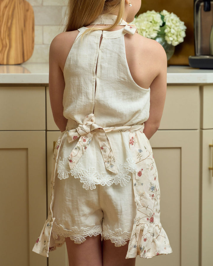 Children’s floral Christmas apron for ages 4–7, featuring premium cotton fabric, front pockets, adjustable waist ties, and sweet ruffle detailing for holiday baking, crafting, dress-up, and mommy-and-me matching.