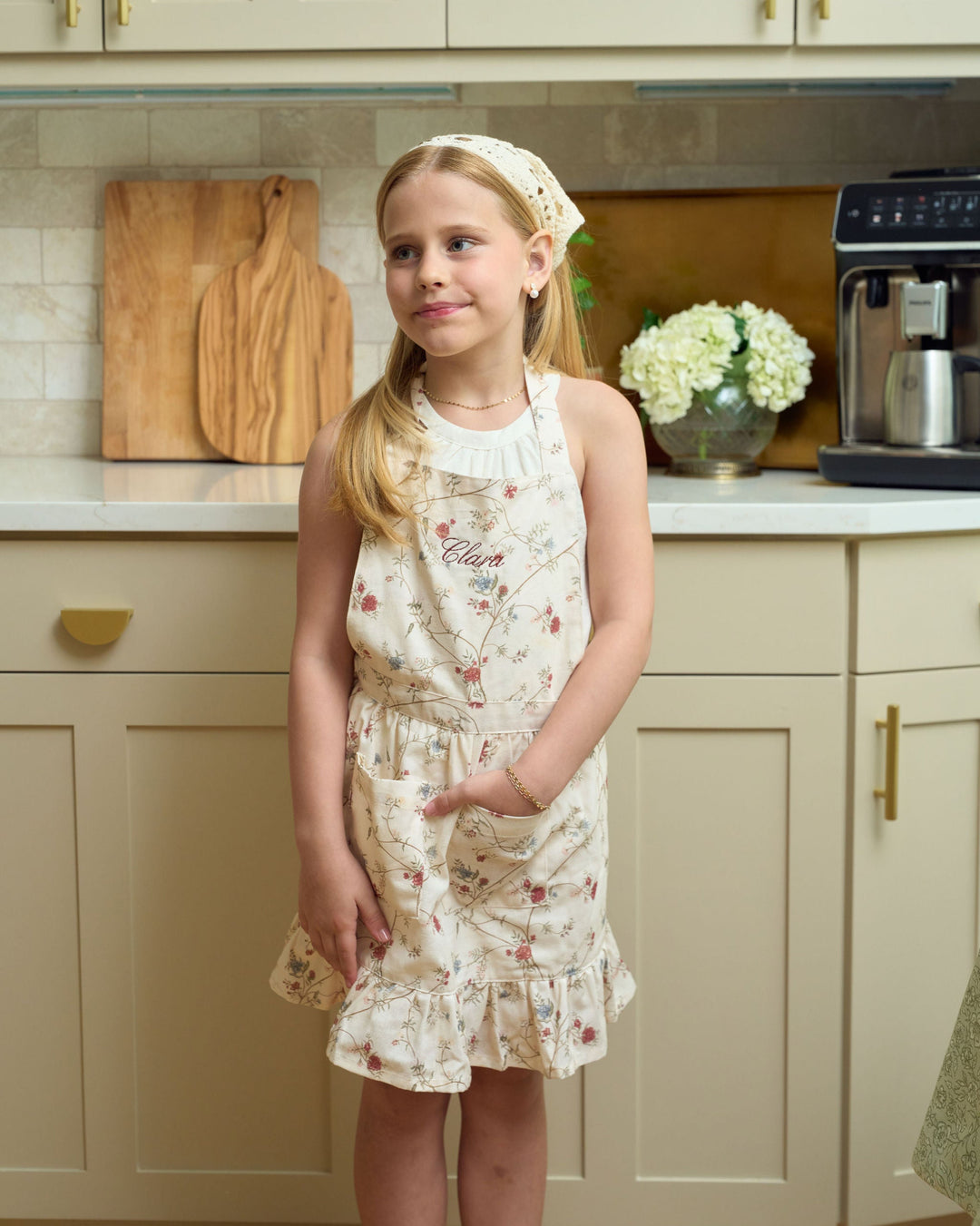 Little girls’ floral cotton apron with ruffle hem, front pockets, and adjustable waist ties, styled for Christmas baking, holiday cookie decorating, Thanksgiving cooking, and festive mommy-and-me kitchen traditions.