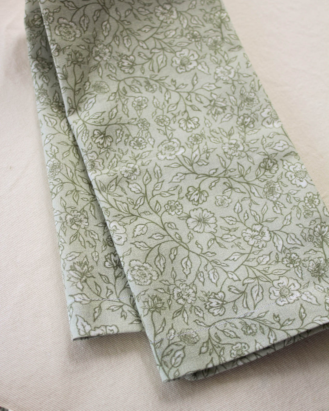 Green cotton tea towel featuring a hand-drawn botanical print, perfect for drying dishes, everyday cooking, and classic kitchen décor.