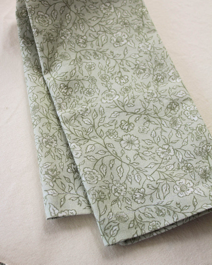 Green cotton tea towel featuring a hand-drawn botanical print, perfect for drying dishes, everyday cooking, and classic kitchen décor.