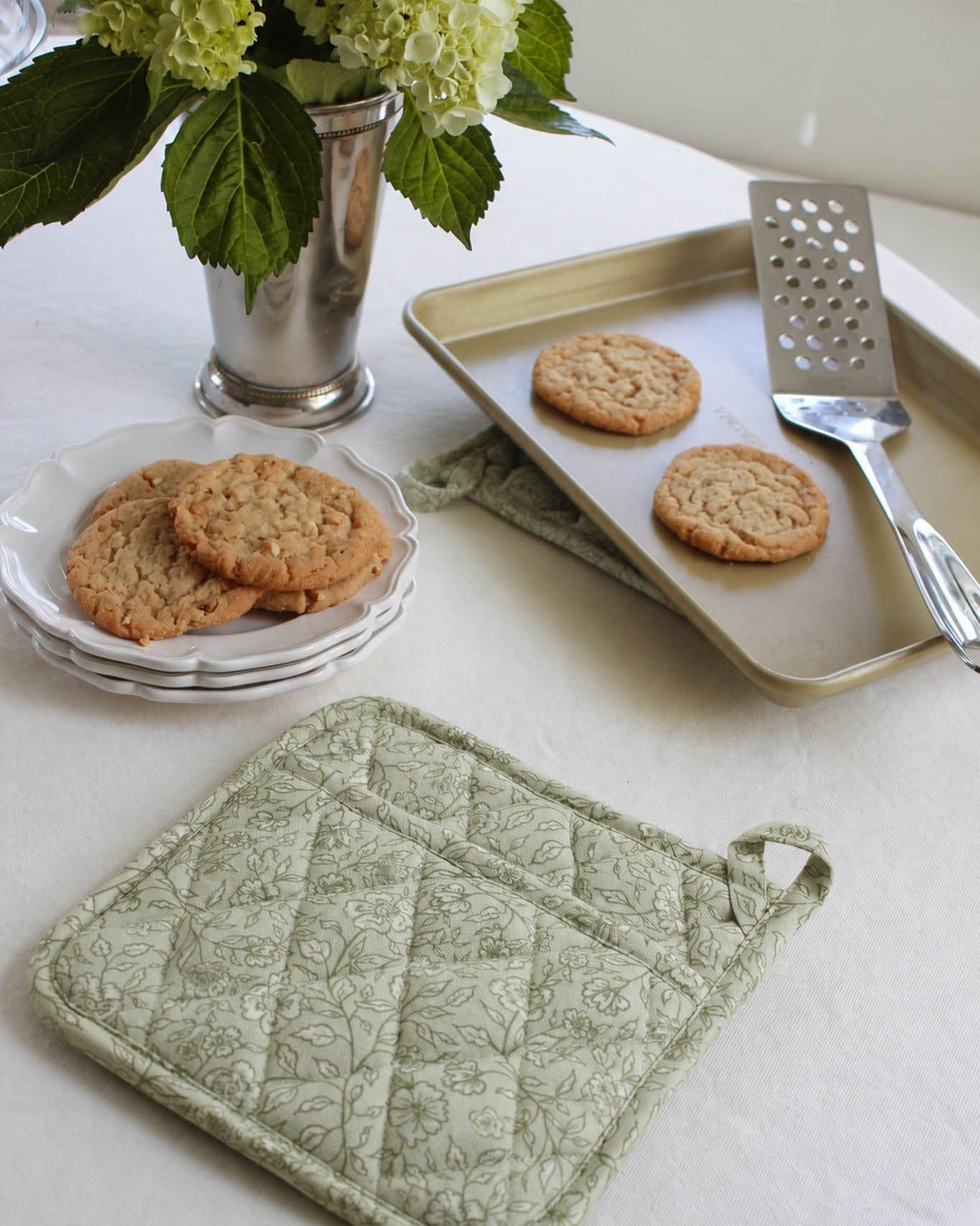 Quilted floral cotton pot holder with a heat-resistant design and hanging loop, made for baking, cooking, and displaying in a beautiful kitchen.