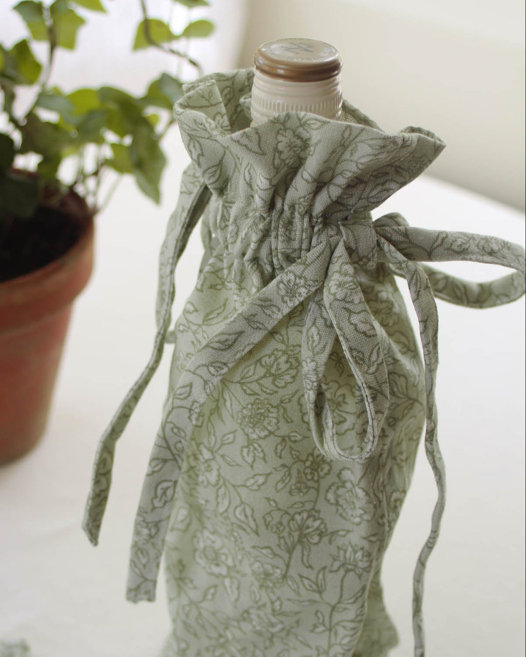 Cotton drawstring wine bag featuring a timeless floral pattern, perfect for hostess gifts, bridal showers, and housewarming celebrations.