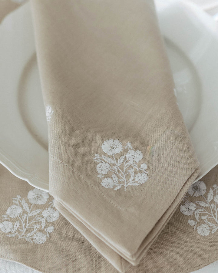These beige  napkins  with white floral embroidery are a versatile addition to your spring linen closet. Sold as a set of 4, the 20x20 cotton-linen napkins are perfect for everything from a casual Easter egg hunt brunch to a formal garden wedding. The delicate white embroidery adds a touch of warmth and country charm to any setting. Whether looking for a gift for mom or updating your own holiday decor, these floral napkins bring a cohesive and sophisticated look to your seasonal table settings.