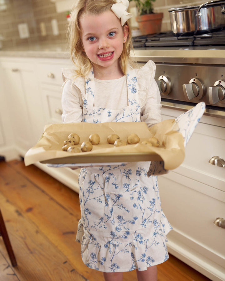 Children’s Garden Vine apron in Delft Blue with ruffle detail and front pockets, ideal for young bakers and kitchen helpers.