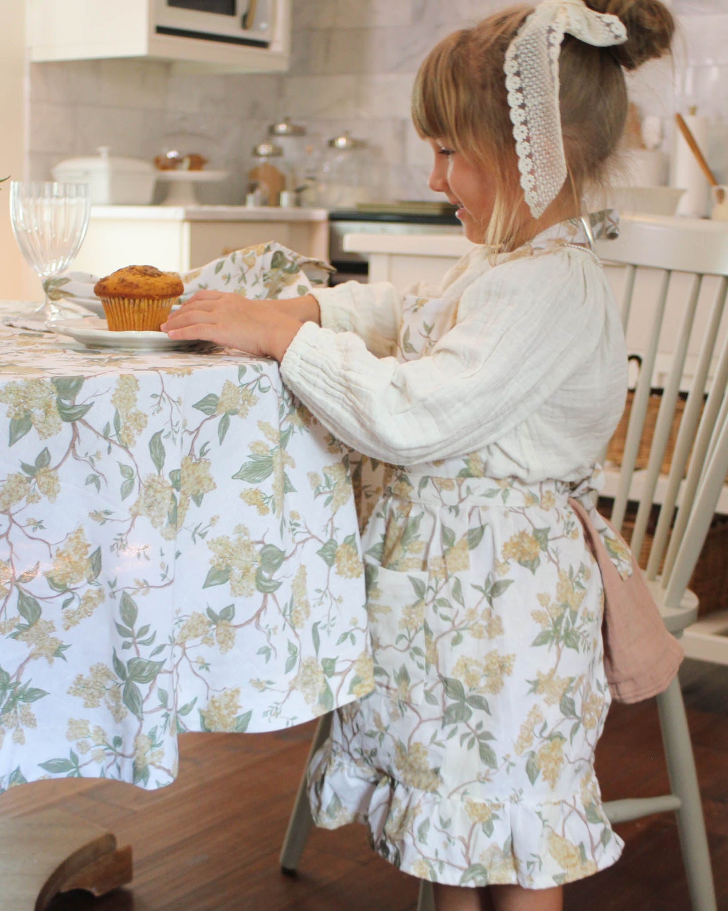 Children’s floral apron with ruffle hem and front pockets