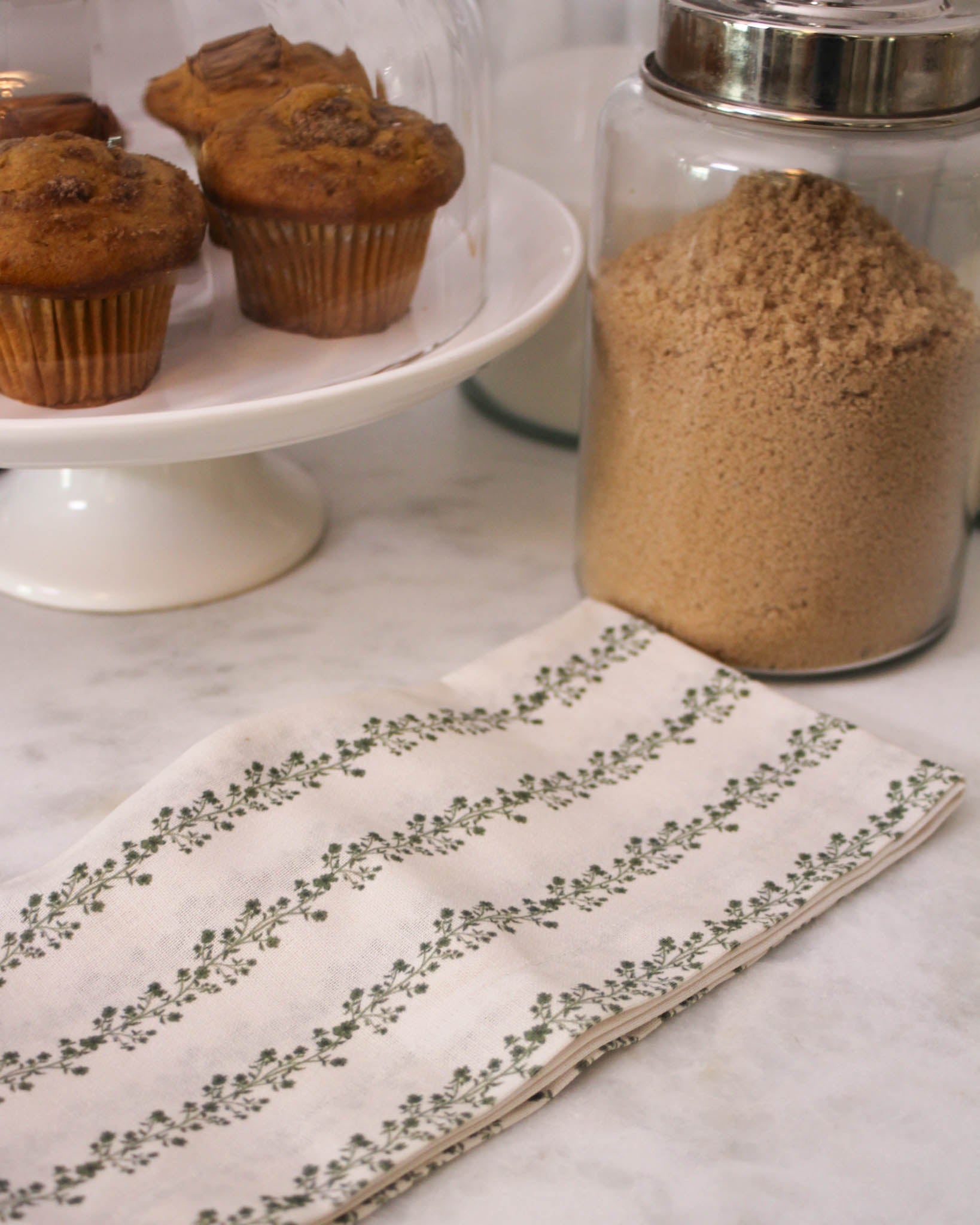 Organic cotton tea towel with hand-drawn Begonia stripe hanging in kitchen