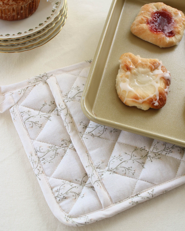 Heirloom-inspired cotton pot holder in an original hand-drawn botanical print, combining practical heat protection with beautiful kitchen décor.