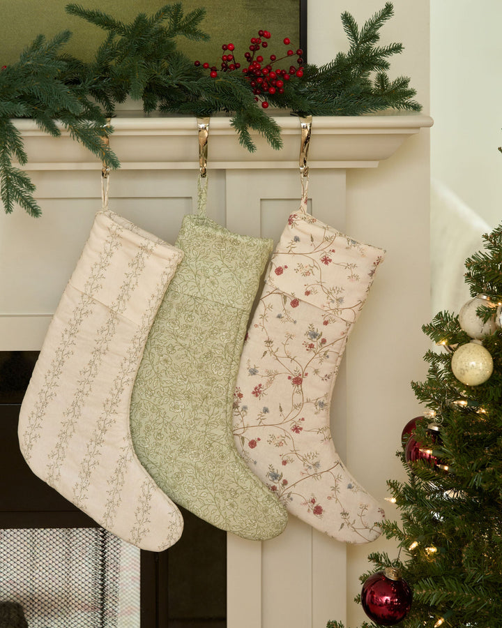 Antique-inspired Christmas stocking with washed red, green, blue, and yellow florals, custom monogram embroidery, and timeless holiday decor for the mantel.