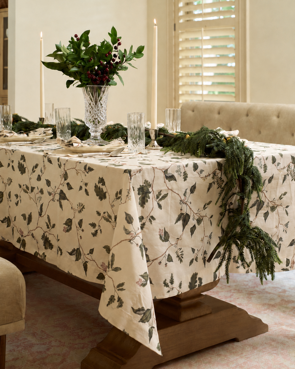 English countryside botanical tablecloth styled for Christmas with neutral holiday table linens, oak garden foliage, taper candles, and cut crystal.