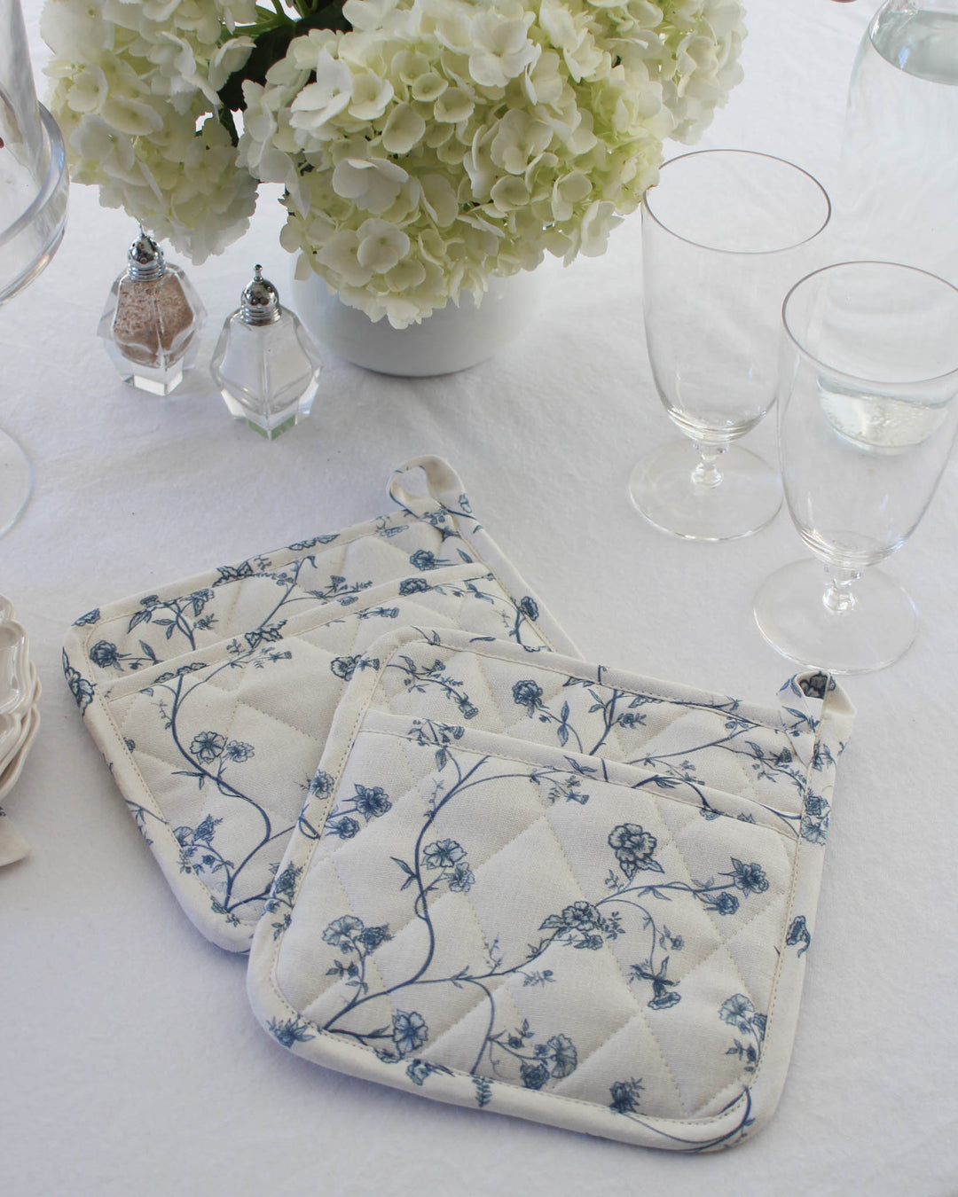 Delft Blue Garden Vine pot holders with diamond stitching and soft floral print, perfect for home chefs and summer gatherings.