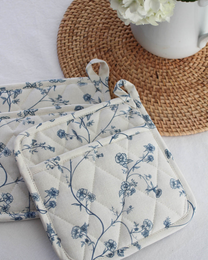 Garden Vine pot holders in blue and white cotton with quilted texture and heat protection, styled for a coastal-inspired kitchen.