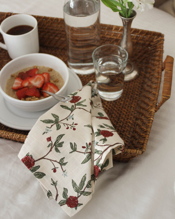 Red and green floral table linens styled for an elegant everyday table with coordinating napkins and classic place settings.