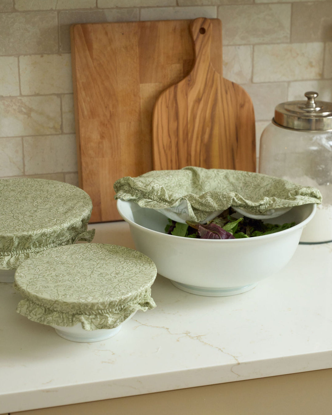 Garden Fields sage green floral cotton bowl cover set with three reusable elasticized sizes and ruffle trim for sourdough proofing, bread dough, food storage, serving bowls, everyday cooking, spring baking, summer hosting, Thanksgiving preparation, Christmas gatherings, and sustainable kitchen use.