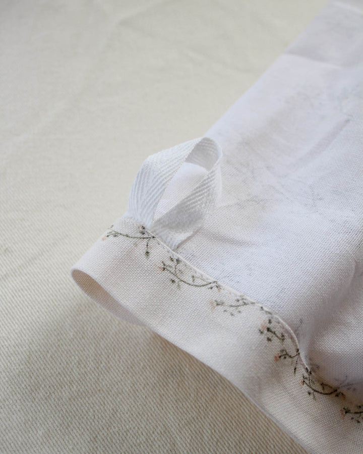 Cotton tea towel featuring a hand-drawn floral print, perfect for drying dishes, lining baskets, and adding timeless style to the kitchen.