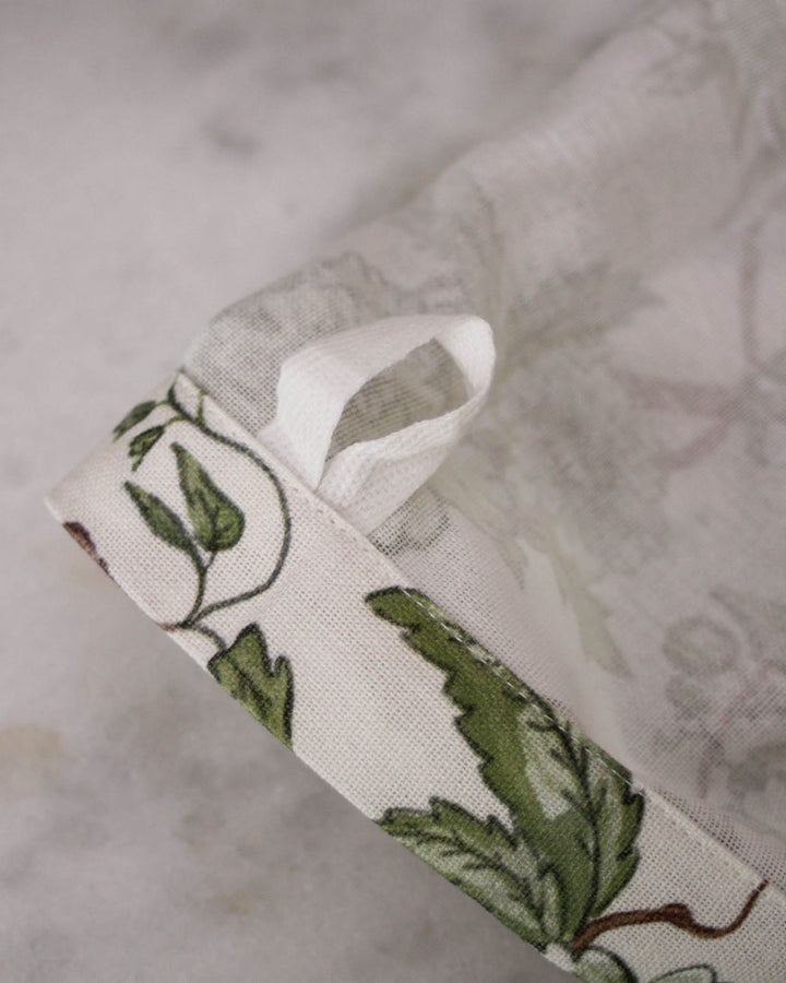 Floral tea towel with hanger loop, designed for drying, baking, and adding a soft decorative touch to kitchens.
